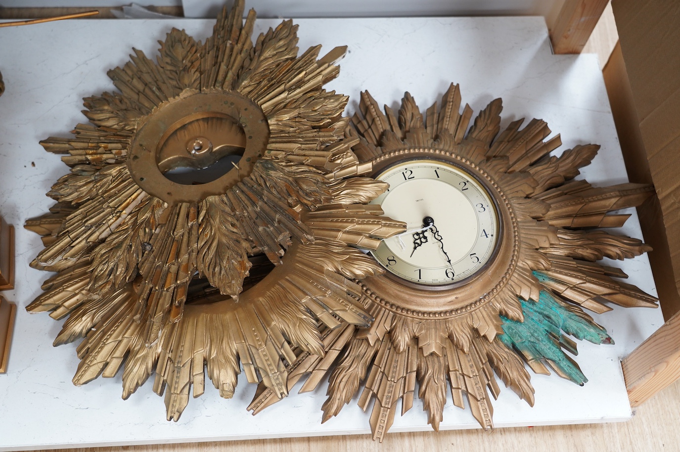 A Smiths gilt sunburst framed wall dial clock and two similar sunburst frames, Smiths clock and frame 69cm wide. Condition - poor to fair